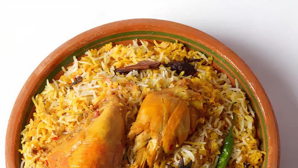 Chicken Biryani · Long grain basmati rice cooked with chicken to perfection over a low flame. Garnished with crispy fried onion. Served with raita.