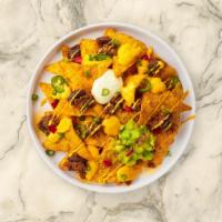 Chili & Cheese Nachos · Salted tortilla chips doused in tomatoes, queso cheese and jalapeño peppers.
