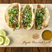 Tacos De Carne Asada · Three steak tacos | cilantro | onions | refried beans.