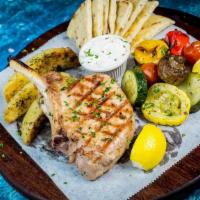 Pork Chop Steak · Marinated pork chop steak, served w/ lemon potatoes & grilled veggies, Tzatziki Sauce & Pita...