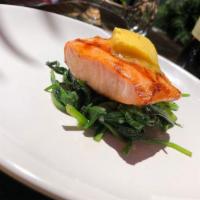 Salmón Al Sarten · Roasted salmon over sautéed spinach with herbed butter.