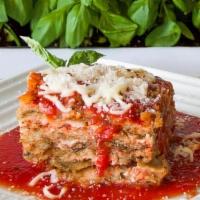 Eggplant Parmesan Entrée · Fried Skinless Eggplant Layered with Homemade Marinara and Mozzarella. Presented Over Spaghe...