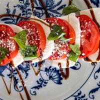 Tomato Caprese · Sliced Roma Tomato Topped with Belgioioso Mozzarella, Basil, Drizzled with Balsamic Reduction.