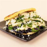 Bean And Cheese Arepa · Crumbled cotija cheese, shredded cheese, black beans, and cilantro between two warm, fresh a...