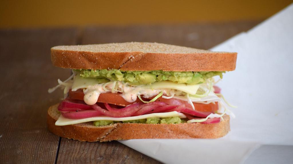 Baja Veggie Sandwich · Avocado, shaved cabbage, pickled red onions, tomato, and pepper jack cheese with a chipotle honey lime yogurt sauce.