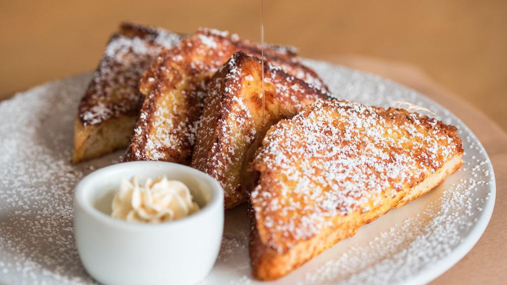 French Toast · Two thick slices of challah bread dipped in egg batter and griddled to a golden brown.