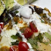 Breakfast Tostada · Fried corn tortilla covered in refried beans with eggs, cheese and avocado/Tortilla de maiz ...