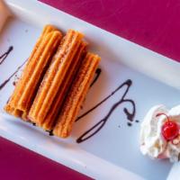Churros · Order of four covered with chocolate syrup and topped with whip cream.