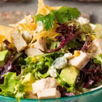 Southwest Chicken Chopped Salad · Crisp greens tossed with avocado, roasted sweet corn, bleu cheese crumbles, and crispy torti...