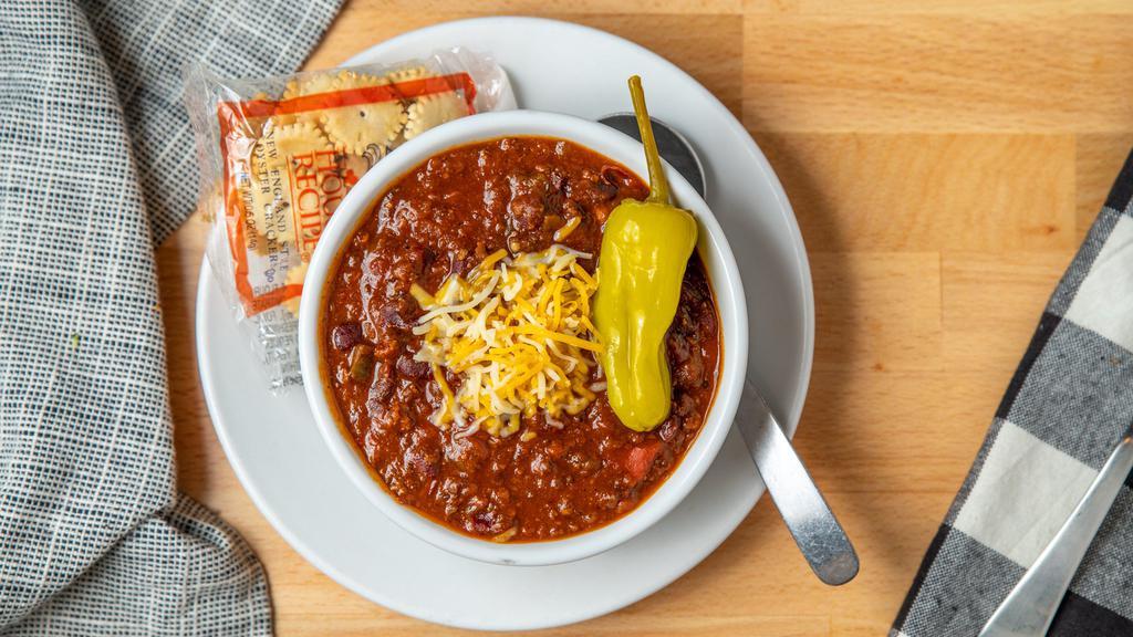 Sneakers Signature Chili · Red chili loaded with lean ground beef, green bell pepper, tomato, green chiles, garlic, kidney beans, lager beer, spices, onion and jalapeno, garnished with shredded monterey jack and cheddar cheese.