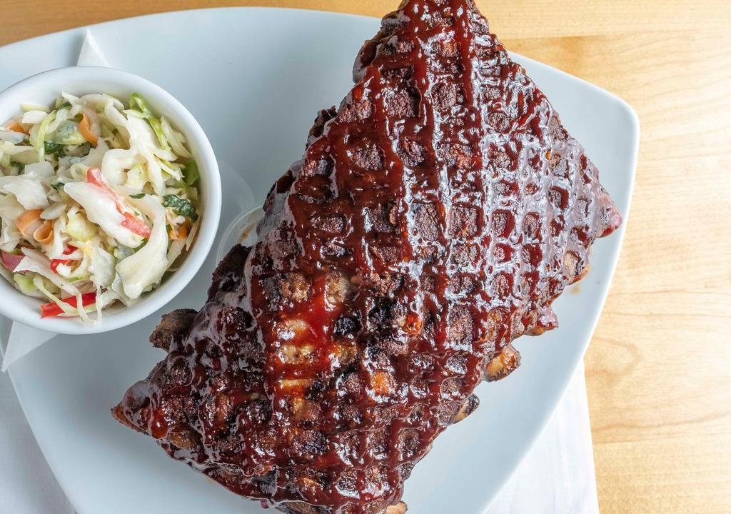Baby Back Ribs · Baby back pork ribs seasoned and slow roasted then glazed and grilled in your choice of bbq or carolina gold, served with fries and our own coleslaw.