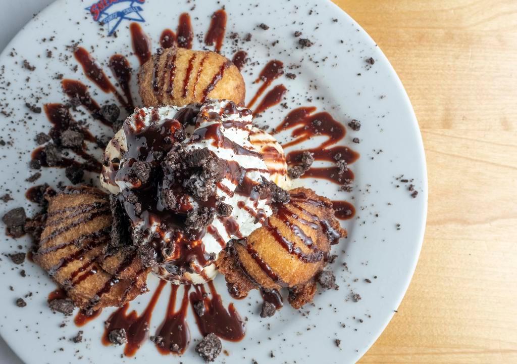 Fried Oreo · Oreo cookies hand dipped in funnel cake batter then golden fried, served with a scoop of vanilla ice cream, topped with chocolate syrup, crumbled oreo's and whipped cream.