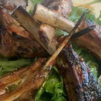 Top Billin Lamb Lollipops · Grilled lamb lollipops with two sides.
