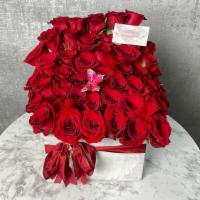 Lydia · Overload of roses arranged to perfection in wooden vase.