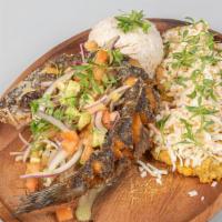 Pescado Frito · Whole deep-fried white fish with fried green plantains, covered with white cheese, avocado, ...