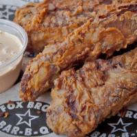 Chicken Fried Ribs · Double sided, thick cut ribs, breaded, fried and served with our white BBQ sauce.