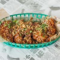 Korean Twice Fried Wings · Twice fried chicken wings tossed in a garlic gochujang sauce and topped with peanuts, sesame...