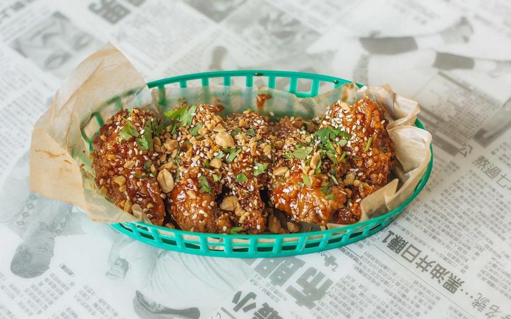 Korean Twice Fried Wings · Twice fried chicken wings tossed in a garlic gochujang sauce and topped with peanuts, sesame seeds and cilantro | Some Heat