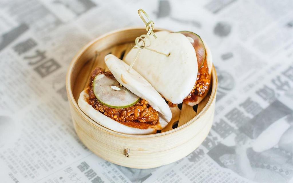 Seoul Hot Chicken Bao · Two fluffy bao buns, filled with juicy 24-hour brined chicken thigh, deep-fried and sauced in garlic gochujang. Topped with a spicy house-made pickle.