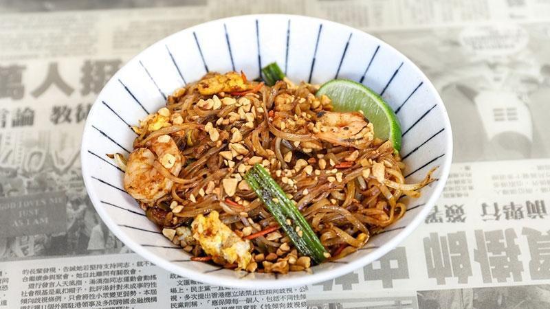 Pad Thai · A Hawkers staple. Rice noodles with shrimp and sliced chicken, wok-fired in a tangy, red chili pepper sauce with eggs, bean sprouts, carrots, and green onions. Topped with roasted peanuts and fresh lime | Some Heat