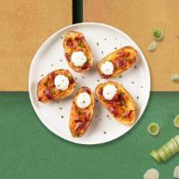 Potato Skins · Baked potato skins filled with cheddar cheese, bacon, scallions, and topped with sour cream.