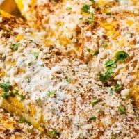 Street Corn · Grilled corn on the cob, coated with a mixture of Mexican Crema, then sprinkled with Cotija ...