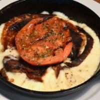 Provoleta · Grilled provolone cheese with fresh oregano and grilled tomato.