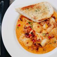 Shrimp & Grits · Lightly seasoned shrimp sautéed with andouille sausage, onions, and peppers. Served in a roa...