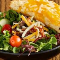 Legendary House Salad · Garden salad topped with bacon and cheese. Served with a piece of cheesy Texas toast..