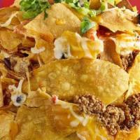 Can Of Nachos · Spicy taco beef, queso, pico de gallo, shredded cheese, black beans, roasted corn and poblan...