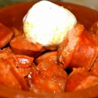 Chorizo A La Sidra - Cider Sausage · Fresh Spanish sausage reduced in Spanish cider and served with creamy goat cheese from La Ma...