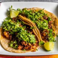 Tacos Al Pastor · Marinated pork with pineapple, onions, and cilantro.