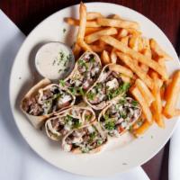 Arabic Beef Shawarma · Slices of marinated beef broiled with tomatoes, pickles, onions, fresh parsley, somaq, and t...