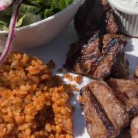 Lamb Shish Kebab · Marinated grilled lamb chunks served with bulgur pilaf and salad.