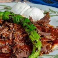 Iskender Kebab · Gyro topped with hot tomato sauce over pieces of pita bread and yogurt.