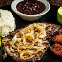 Palomilla Steak Plate · Marinated thin cut steak grilled with homemade mojo, topped with sauteed onions. Served with...