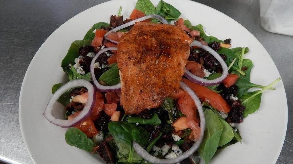 Salmon Salad · Fresh grilled Atlantic salmon atop. a bed of spinach with bacon, bleu. cheese crumbles, tomatoes, red. onion and dried cranberries.