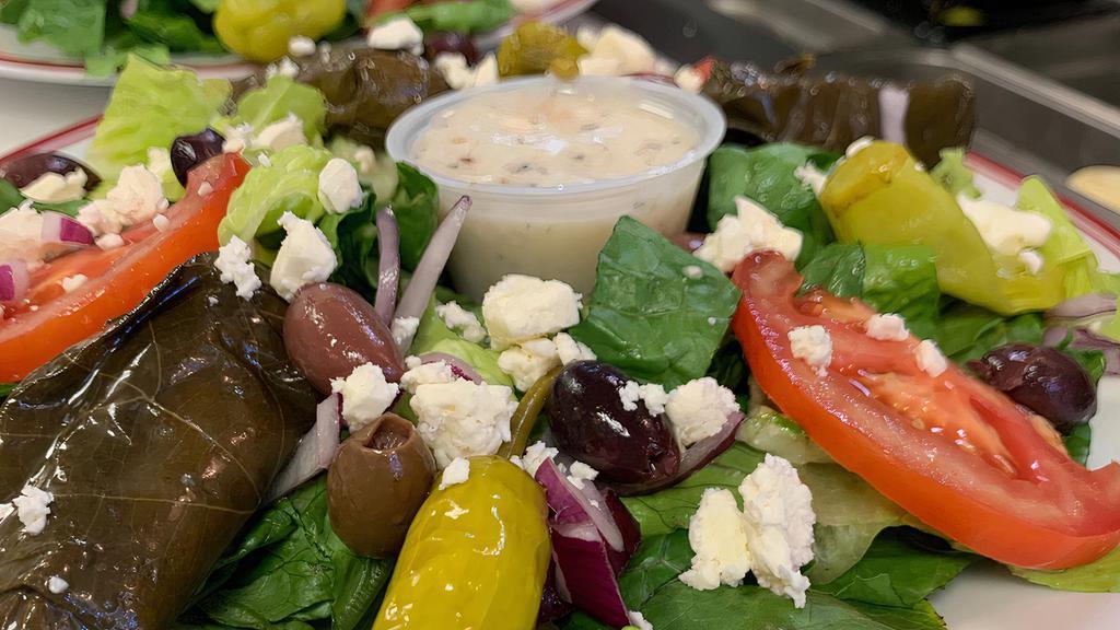 Greek Salad · Lettuce, tomato, onions, black olives, pepperoncini, green bell pepper, stuffed grape leaves, and feta cheese.
