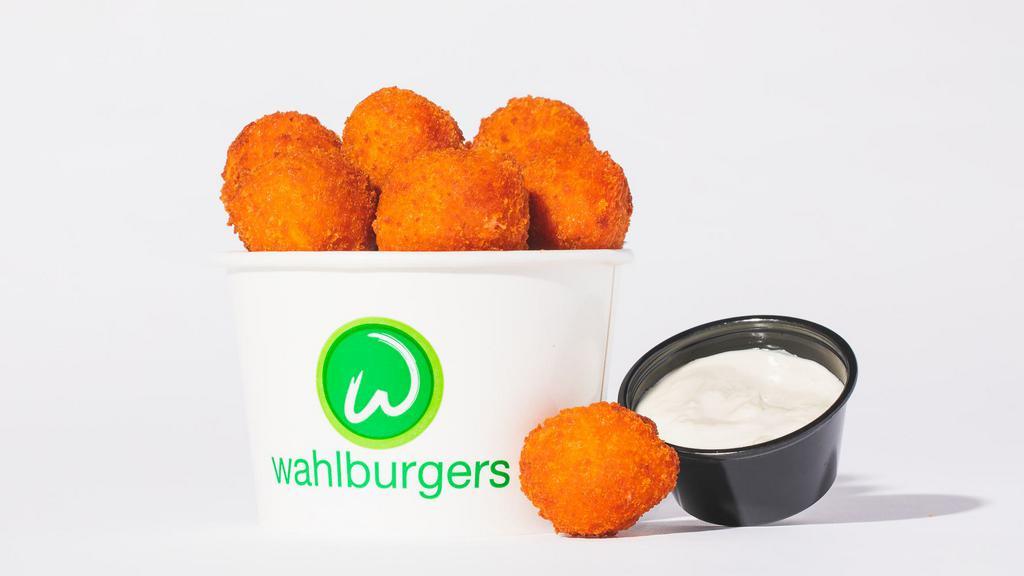 Buffalo Chicken Wahlbites · Bold fried Buffalo chicken bites served with a tangy blue cheese sauce 590 Cal.