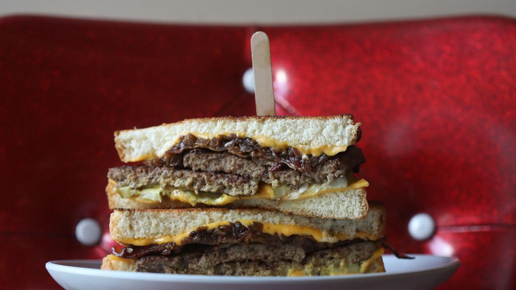 The Super Melt · 2 beef burger patties, government cheese, bacon, caramelized onions, pickles, & housemade mustard sauce served between thick-cut bread & grilled  1120 Cal.