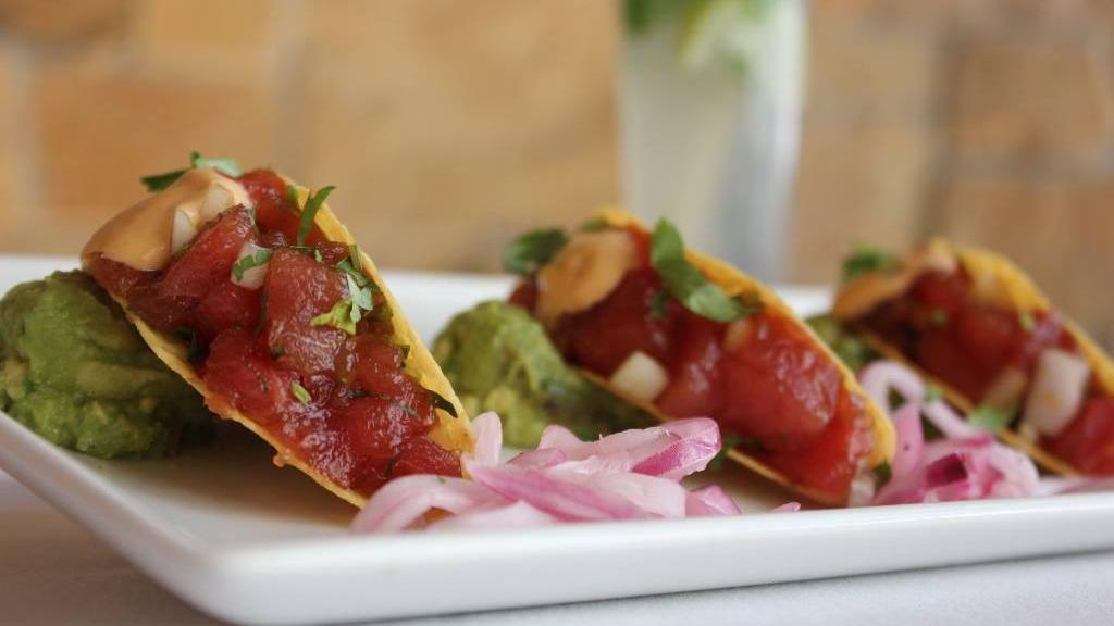 Ahi Tuna Tacos · Signature dish. Three crisp sushi-grade tuna tacos, jicama, ginger slaw, guacamole, pickled red onion, and chipotle aioli.

*Consuming raw or undercooked meats, poultry, seafood, shellfish or eggs may increase your risk of foodborne illness, especially if you have certain conditions.