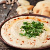 Hummus · Cooked and blended garbanzo beans mixed with tahini sauce, lemon juice, and garlic served wi...