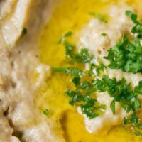 Baba Ghanouj · Fire-roasted eggplant blended with tahini, spices, and garlic served with pita bread.