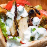 Chicken Shawarma · Thin slices of marinated chicken cooked on a slowly revolving rotisserie, served in a pita b...