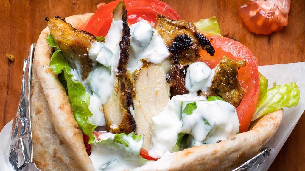 Chicken Shawarma · Thin slices of marinated chicken cooked on a slowly revolving rotisserie, served in a pita bread with lettuce, tomatoes, onion, pickles and tahini sauce.