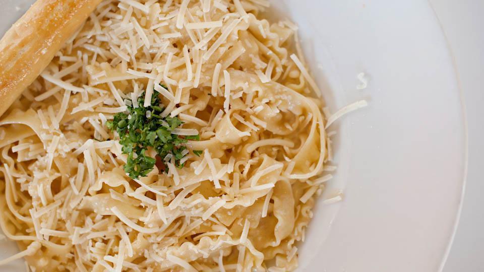 Fettuccini Alfredo · Fettuccini pasta tossed with our freshly-made cream sauce. Garnished with freshly grated Parmesan and Romano cheeses.