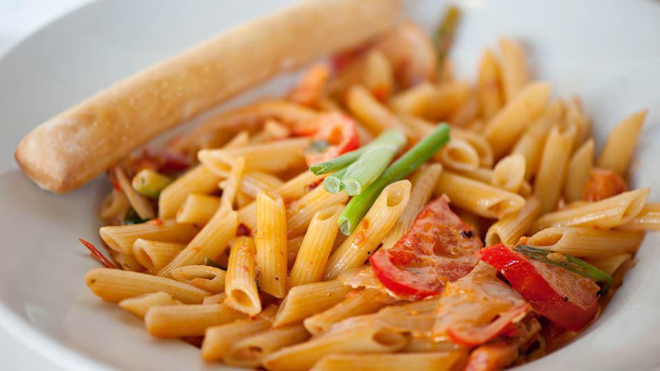 Spicy Cajun Pasta · Penne pasta tossed with our rustic tomato cream sauce, scallions, fresh yellow onions and red bell peppers. Garnished with scallions.