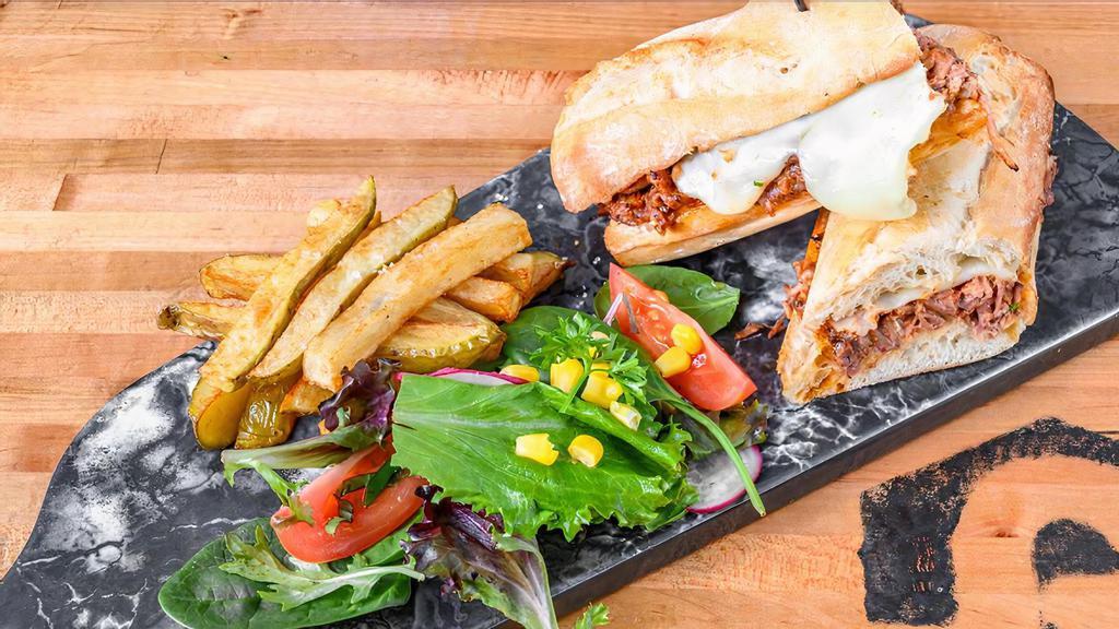 Slow Cooked Short Rib Sandwich · Slow cooked short rib topped with melted Gouda cheese served in a French baguette with your choice of french fries or house salad