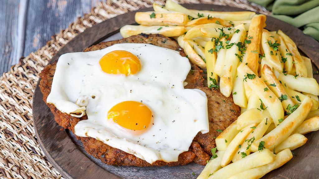 Chicken Milanesa A Caballo · Topped with 2 fried eggs served with french fries or house salad