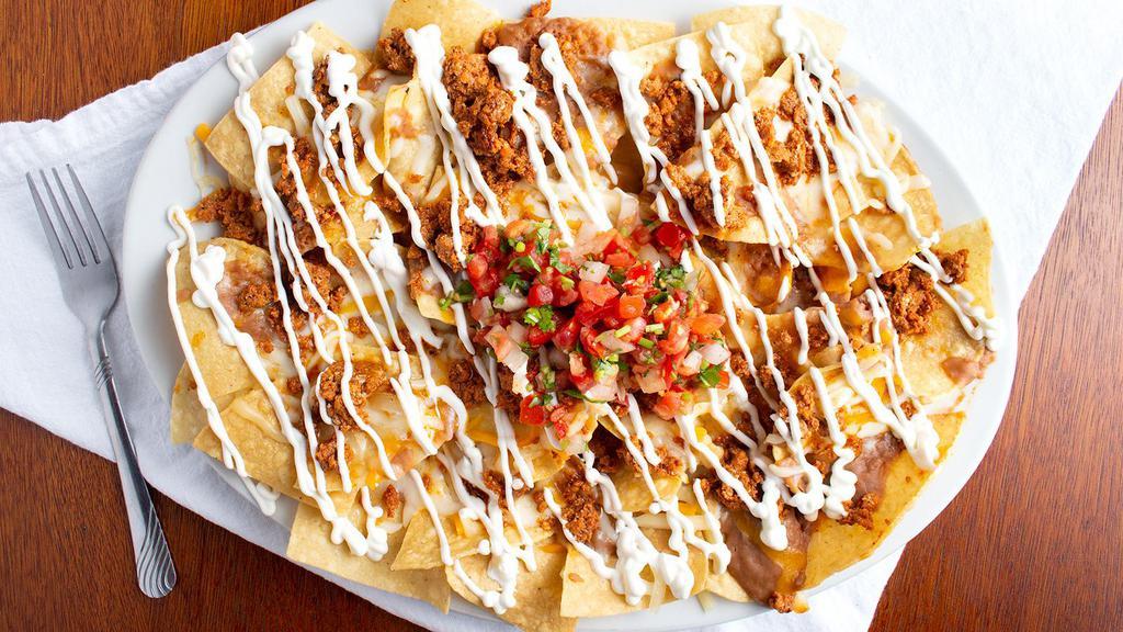 Nachos · Nachos with refried beans and melted cheese, pico de gallo and sour cream on the top.